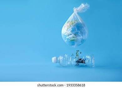  A Globe In A Plastic Bag Over A Plastic Bottle, From Which Sprouts Are Sprouting. Copy Space. Selective Focus.                              