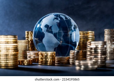 Globe and stack with coins. Money makes the world go round - Shutterstock ID 2154195865