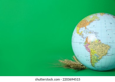 Globe With Wheat Spikelets On Green Background, Space For Text. Hunger Crisis Concept