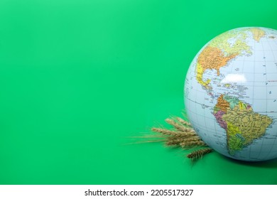 Globe With Wheat Spikelets On Green Background, Space For Text. Hunger Crisis Concept