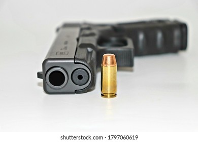 A Glock 23 Gun With A Brass Or Copper Bullet. 