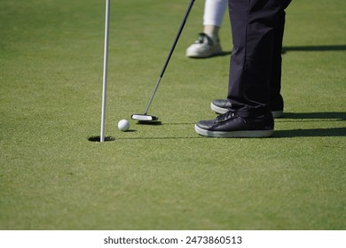 Glofer takes a stance to put a golf ball in the hole - Powered by Shutterstock