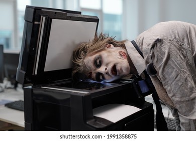 Gloomy Man With Zombie Greesepaint On Face Keeping Head On Screen Of Xerox Machine