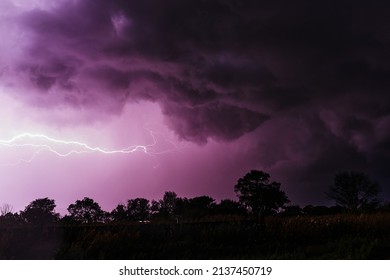 gloomy, mystical purple storm sky with lightning discharges and gloomy swirling clouds