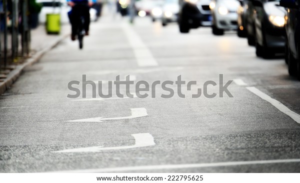 Gloomy road with\
arrows, bicylist distant