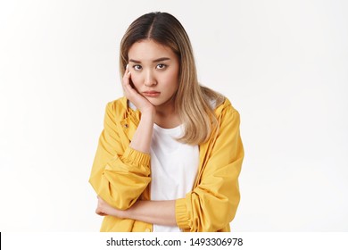 Gloomy young sad asian blond girl sighing upset stoop look from under forehead lonely unhappy lean palm bored feel regret sadness moody expression standing white background pessimistic - Powered by Shutterstock