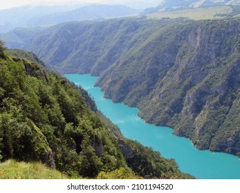 A Glorious Landscape Of An Azure River Flowing Through The Mountains