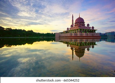 Glorious Sunrise view with reflection image on the lake of Masjid Putra, Putrajaya. Image has grain or blurry or noise and soft focus when view at full resolution (Shallow DOF, slightly motion blur).