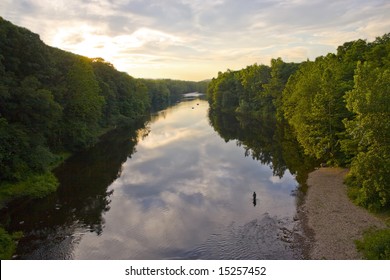 A glorious view of the Farmington River around dusk.  A patient fly fisherman is seen enjoying his hobby.