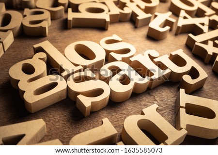 GLOSSARY word by wood alphabets with many random letters around