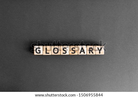 Glossary - word from wooden blocks with letters, alphabetical list with words meanings dictionary glossary  concept, top view on grey background