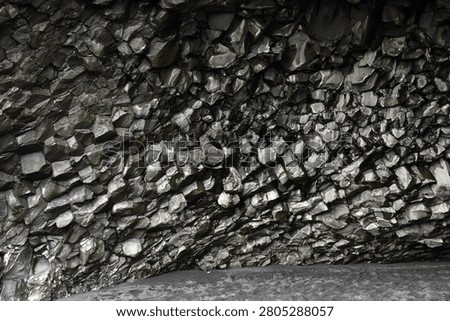 Glossy basalt column wall inside Halsanefshellir cave on Reynisfjara beach, Iceland