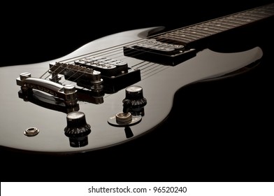 glossy black electric guitar isolated on black background, glänzende schwarze E-Gitarre vor schwarzem Hintergrund