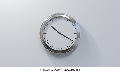 Glossy chrome clock on a white wall at twenty past ten. Time is 10:20 or 22:20