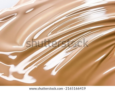 Glossy cosmetic texture, beige liquid foundation or concealer as beauty make-up product background, skincare cosmetics and luxury makeup brand design concept