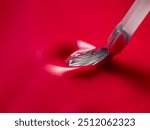 The glossy and smooth texture of the vivid red nail polish is perfectly demonstrated by light brush stroke on the surface