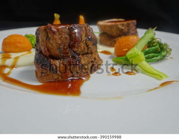 Glossy veal demi-glace sauce, highly\
reflective, decorating white plate with seared beef filet and\
vegetables. More angles available from this\
shoot.