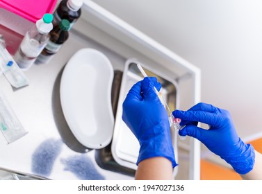 Gloved hand hold the pipette with blood for analysis. Plastic labware for scientific research. Scientist is analyzing blood sample in laboratory.