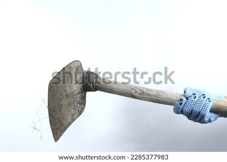 Gloved hand holding hoe isolated on white background
