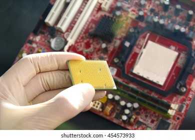 Gloved hand holding microprocessor chip