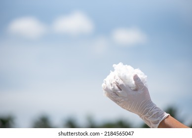 Gloved Hand Holding Polyester Staple Fiber Against Blue Sky Background