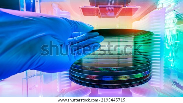 Gloved Hand Holding a Silicon Wafer in plastic\
holder box used in electronics for the fabrication of integrated\
circuits