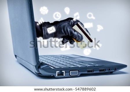 A gloved hand reaching out through a laptop holding debit or credit card with common media icons flowing, signifying a cyber crime or Internet theft while using various Internet media.