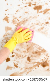 Gloved Hand Wiping A Dirty Counter Top Or Floor With A Pink Sponge