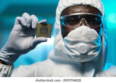 Gloved Hand Of Young African Scientist Holding Microchip While Standing In Front Of Camera And Looking At You