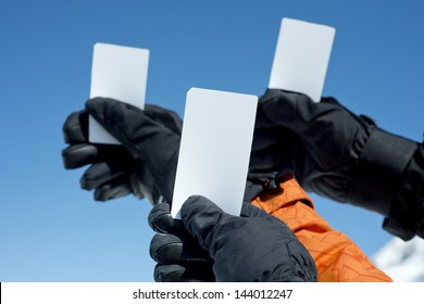 Gloved Hands Holding Lift Pass Against Blue Sky. Concept To Illustrate Ski Admission Fee