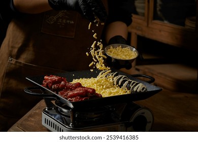 Gloved hands sprinkle grated cheese on black sausages garnished with sauce on a griddle. Chinese word means Roasted sausages cooking. - Powered by Shutterstock