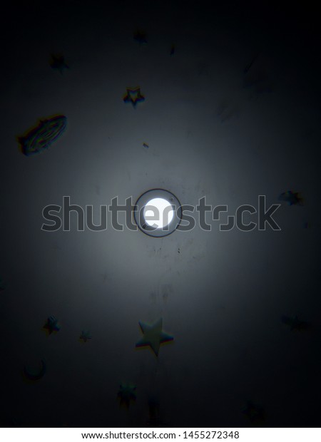 Glow in the Dark Stars around a lightbulb on a\
bedroom ceiling