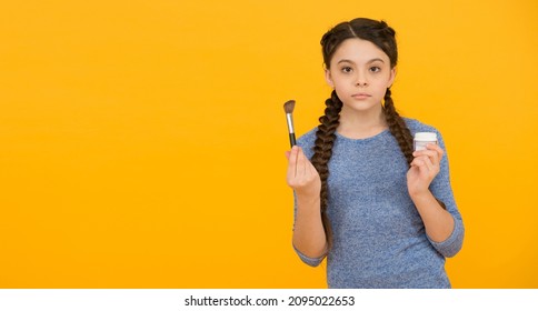 Glow Everyday. beautiful teen girl doing makeup using powder brush. skincare concept. applying makeup on a healthy skin. child make up products. copy space. studio shot of young girl doing make up