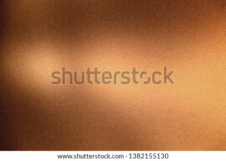 Glowing bronze rough metal wall, abstract texture background
