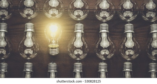 glowing bulb uniqueness concept on brown wooden table