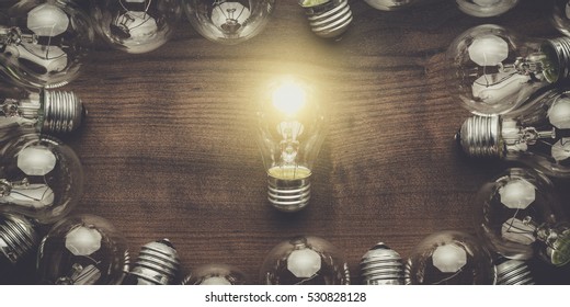 glowing bulb uniqueness concept on brown wooden table