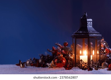 Glowing Christmas lantern and decor of fir tree branches and baubles in snow - Powered by Shutterstock