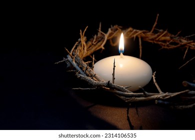 Glowing Easter candle with  a crown of thorns on black - Shutterstock ID 2314106535