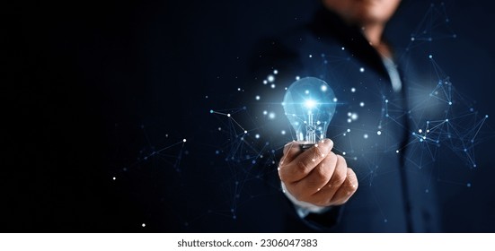 Glowing illuminated blue lightbulb in businessman hand with network connection line. Innovative idea and inspiration concept. Business man in suit holding creativity bulbs shining and glittering.