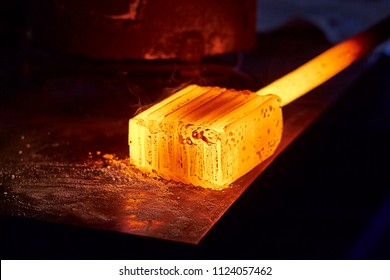 Glowing Iron Ingot On The Table. Hot Metal Workpiece For The Manufacture Of Damascus Steel.