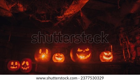 Glowing jack o lanterns carved from real pumpkins at night.