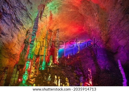 Glowing lights in Huanglong cave (name of the cave), Zhangjiajie, Hunan, China. Colorful images, background, wallpaper. Purple, green, yellow, red stalactites and stalagmites. Geology