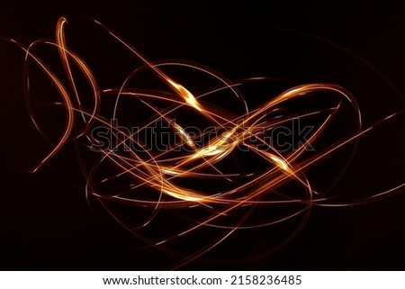 Glowing magic light effect and long trails fire motion. Abstract blue background with lines. draw light lines with lights LED with image blur.