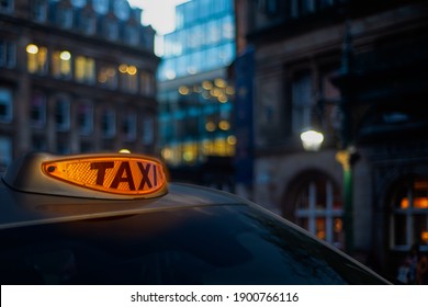 A Glowing Orange Taxi Light In A London Street At Twilight - Powered by Shutterstock