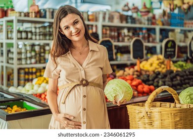 A glowing pregnant woman after forty makes a healthy choice as she selects organic vegetables and fruits at the vibrant organic market, prioritizing her well-being and her baby's health - Shutterstock ID 2346061295