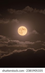 glowing red full moon in the night sky. night dark sky full of cloud with red full moon.