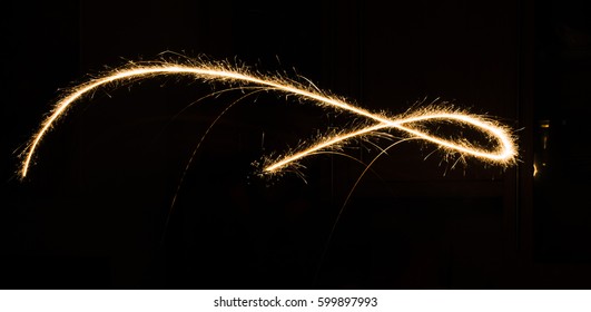 A Glowing Red Hot Sparkler Light Trail Isolated In Dark Environment Using Slow Shutter Speed.