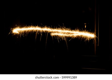 A Glowing Red Hot Sparkler Light Trail Isolated In Dark Environment Using Slow Shutter Speed.