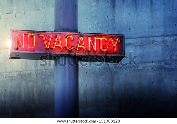 Glowing retro neon \'no vacancy\' sign against\
cool blue wall\
background