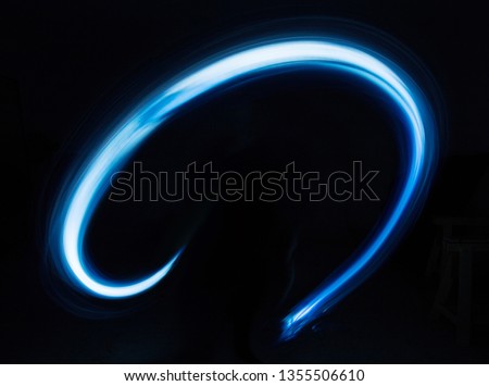 Glowing shiny curve light trail lines effect in black background.